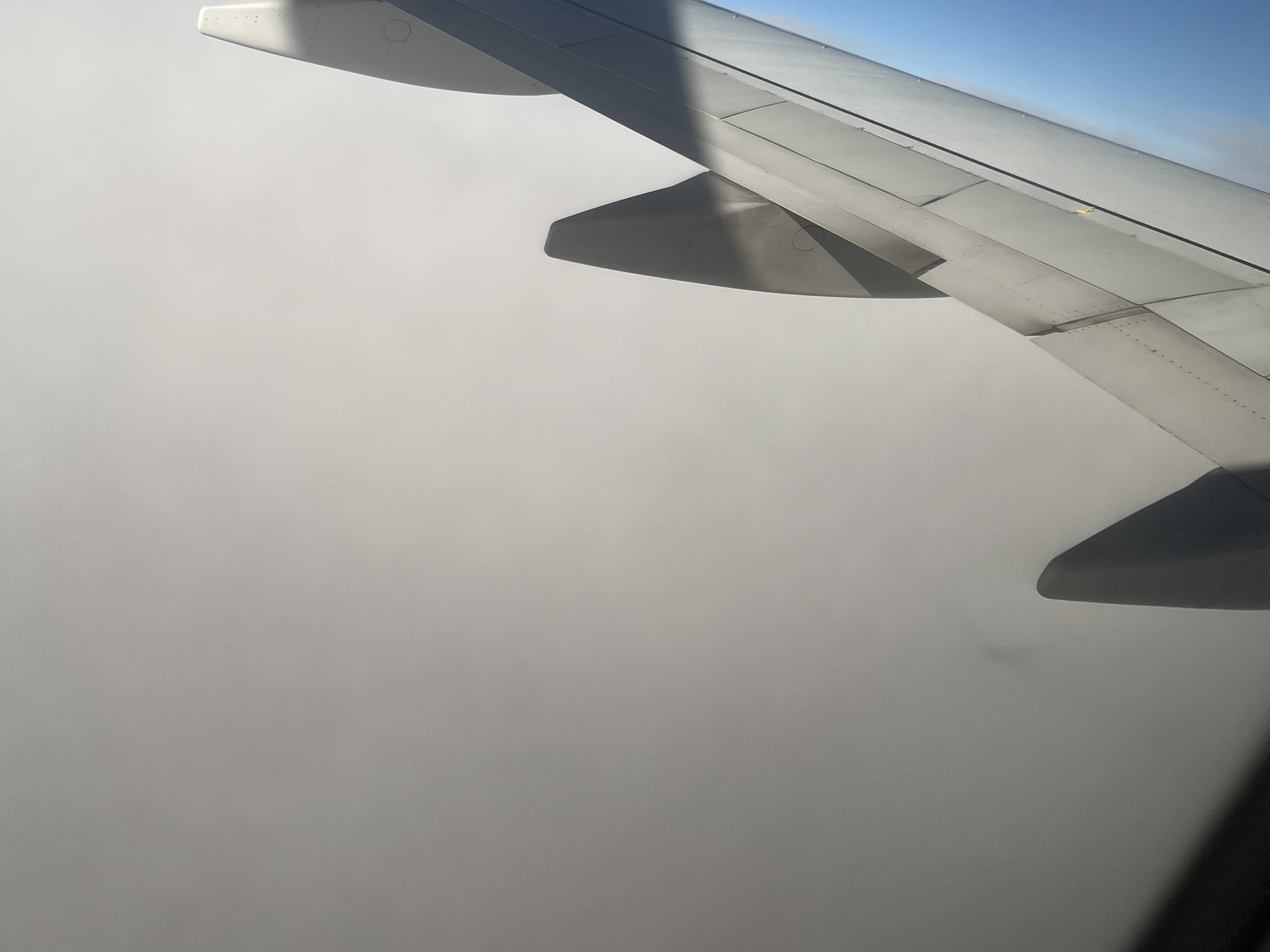 It is sometimes possible to see a faint shadow of the plane on the clouds (bottom right half of the picture near the wing). This is the location of the antisolar point. Here you can once again imagine a line from the sun, through your eyes and the shadow is located where that line extends into the clouds. This is the antisolar point and if the antisolar halos were going to be present, this is where they would center. If these were water clouds, this is where a glory would be visible. None of that was the case at this time.