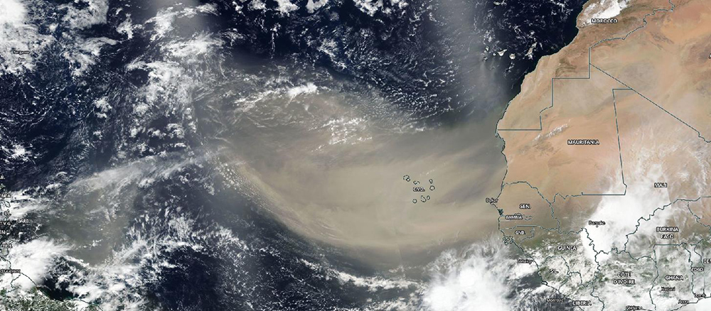 Satellite image showing the northwest coast of Africa in brown with blue ocean and white clouds